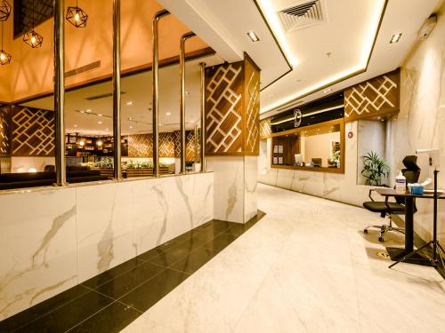 a lobby of a restaurant with a table and mirrors at White Diamond Hotel Sari in Jeddah