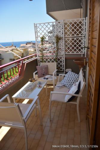 - un balcon avec une table et des chaises dans l'établissement Le Note del Mare appartamento vista mare, à Roccalumera