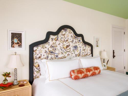 um quarto com uma grande cama branca e uma cabeceira floral em Cambridge Beaches Resort and Spa em Somerset