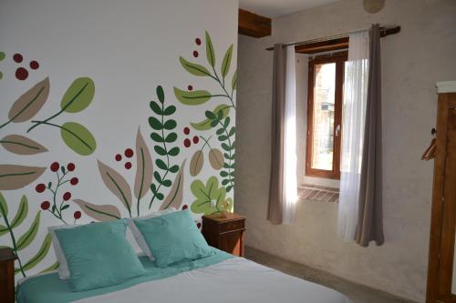 1 dormitorio con 1 cama con un mural floral en la pared en La métairie du château le Vignau, en Le Vignau