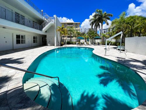 a swimming pool with an umbrella in front of a building at Royal Palms Resort & Spa in Fort Lauderdale