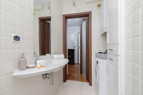W białej łazience znajduje się umywalka i lustro. w obiekcie Cracow Skałki Twardowskiego Tyniecka by Renters w Krakowie