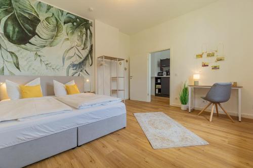 a bedroom with a bed and a painting on the wall at modernes Apartment - zentral, ruhig, Wlan, Netflix, Küche, Schreibtisch, Parkplatz, Waschtrockner in Cottbus
