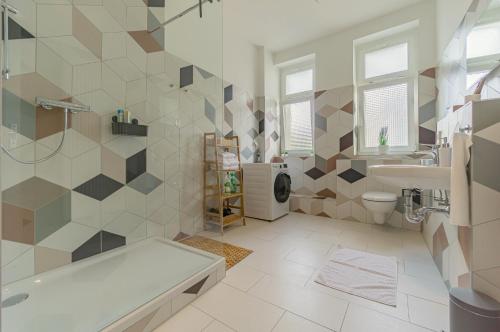a bathroom with a tub and a toilet and a sink at modernes Apartment - zentral, ruhig, Wlan, Netflix, Küche, Schreibtisch, Parkplatz, Waschtrockner in Cottbus