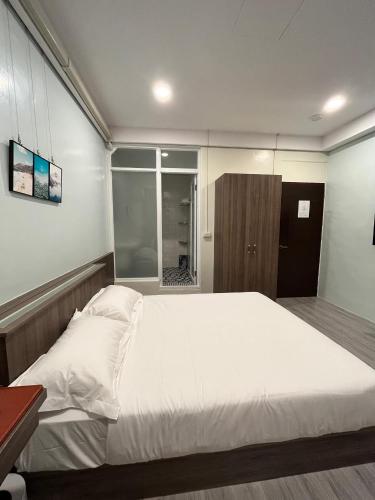 a bedroom with a large white bed and a window at ChaoChaoINN in Chaozhou