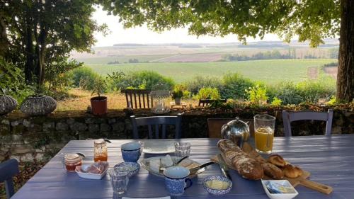 einen blauen Tisch mit Brot und Gläsern Orangensaft in der Unterkunft Domaine de la Boissière in Marigny-Marmande
