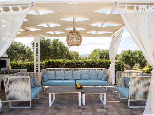 a patio with a blue couch under a white canopy at Villa Daphne in Pangalochori