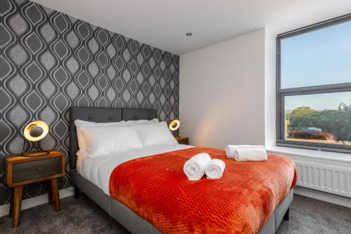 1 dormitorio con 1 cama con 2 toallas en Victoria Place - 3-bed apartment, parking, Wi-Fi en Hyde