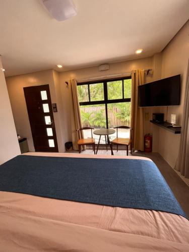 a bedroom with a large bed with a large window at Southseas Beach Resort and Dive Center in Santander