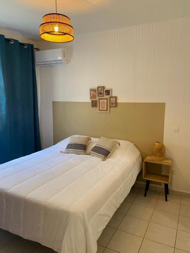 um quarto com uma grande cama branca num quarto em Appartement cosy à Grand Case, proche aéroport. em Grand Case