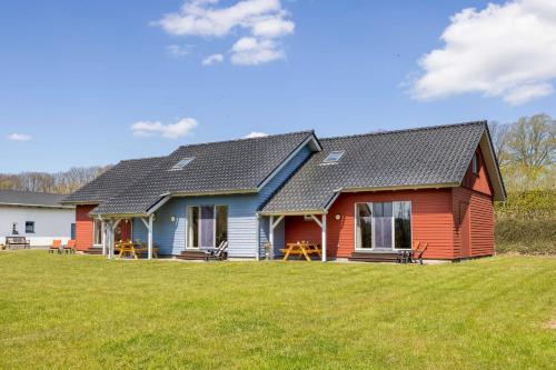 a red and blue house on a grass field at Ostsee Landurlaub auf dem Ferienhof OFC 21 in Kröpelin