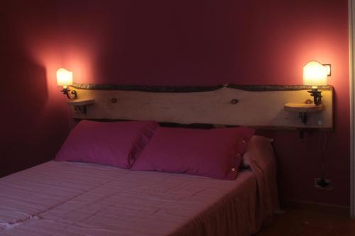 - une chambre avec un lit et deux lumières sur le mur dans l'établissement B&B Il Cedro, à Gênes