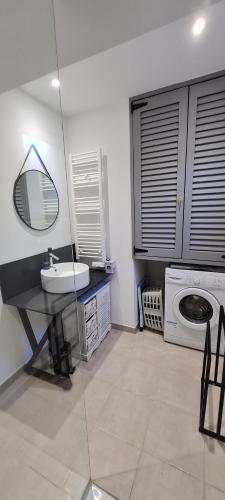 uma casa de banho com um lavatório e uma máquina de lavar roupa em Gîte La Volière em Cardet