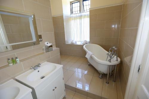 a bathroom with a sink and a bath tub and a sink at Hellaby Hall Hotel; BW Signature Collection in Hellaby