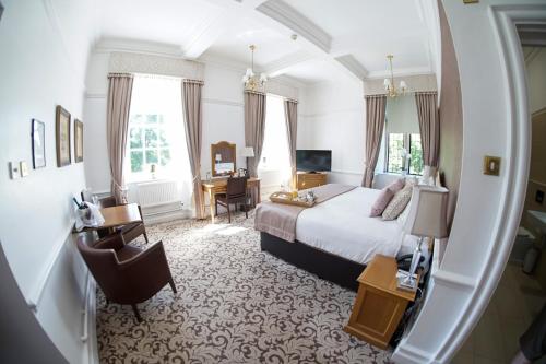 a bedroom with a bed and a desk and a chair at Hellaby Hall Hotel; BW Signature Collection in Hellaby