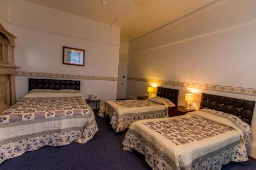 a hotel room with two beds in a room at The Carlton Hotel in Folkestone