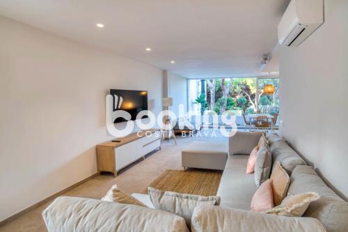 uma sala de estar com um sofá e uma televisão em Margaritas II Apartament renovat per 4 persones amb totes les comoditats em Platja d'Aro
