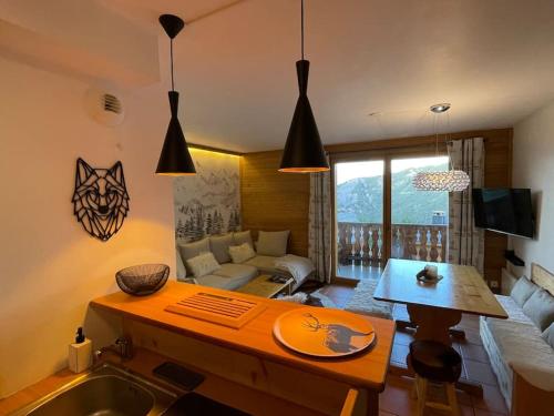 een keuken en een woonkamer met een tafel en een bank bij Appartement COSY à Praloup, 43m2, vue magnifique in Uvernet
