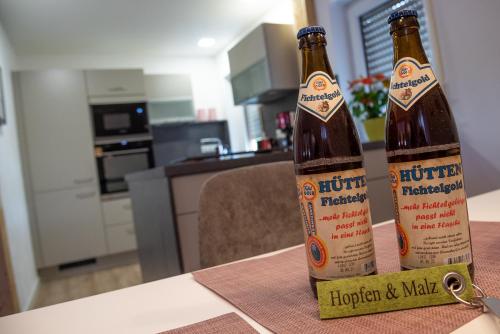 two bottles of beer sitting on top of a table at Ferienwohnungen Hopfen und Malz in Fichtelberg