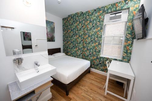łazienka z łóżkiem, umywalką i oknem w obiekcie The Flat NYC w Nowym Jorku