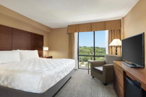 アーリントンにあるHoliday Inn National Airport/Crystal City, an IHG Hotelのベッドとテレビが備わるホテルルームです。