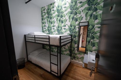 a small bedroom with a bunk bed with a mirror at The Flat NYC in New York