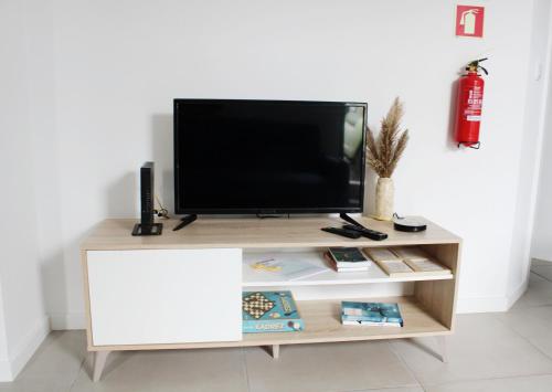 a tv stand with a television on top of it at Casa das Nobres in Évora