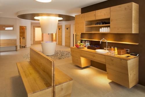 a kitchen with wooden cabinets and a sink at "Fewo am Dorfplatz" - Annehmlichkeiten von 4-Sterne Familien-und Wellnesshotel Viktoria können mitgenutzt werden in Oberstdorf