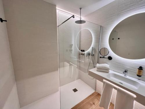 a white bathroom with a sink and a mirror at Hotel Primavera Park in Benidorm