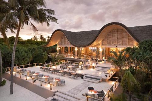 an aerial view of a resort with tables and chairs at JOALI BEING in Raa Atoll