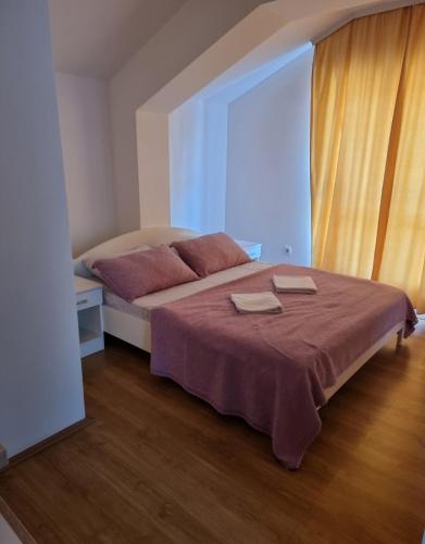 a bedroom with a bed with two towels on it at Apartmani Selektor in Bijelo Polje