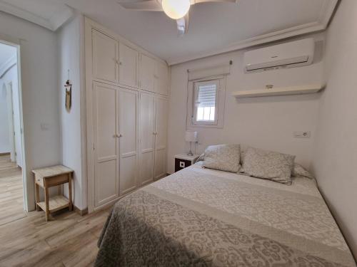 biała sypialnia z łóżkiem i szafką w obiekcie Precioso apartamento centro Sevilla zona Nervión. w Sewilli