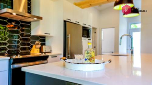 a kitchen counter with a bottle of alcohol on it at La Sunny-Haus de Portneuf / 25 min from Quebec City in Pont-Rouge