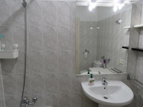 a bathroom with a sink and a shower with a mirror at lidl Bright Central Two Bed Apartment PDC in Puerto del Carmen