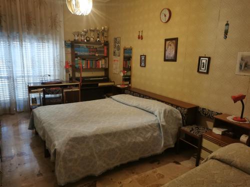 a bedroom with a large bed and a desk at Comodo appartamento in zona centrale e strategica. in Lamezia Terme