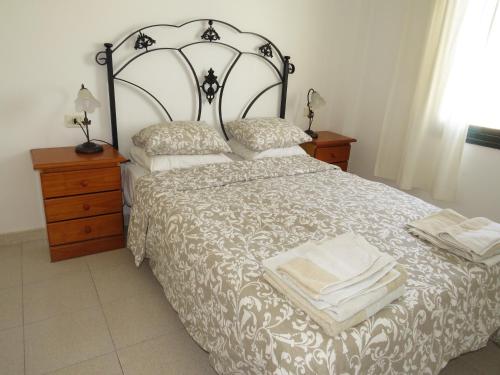 a bedroom with a bed and two night stands and a window at lidl Bright Central Two Bed Apartment PDC in Puerto del Carmen