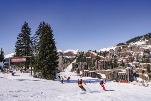 a group of people skiing down a snow covered slope at Belambra Clubs Avoriaz - Les Cimes du Soleil in Avoriaz