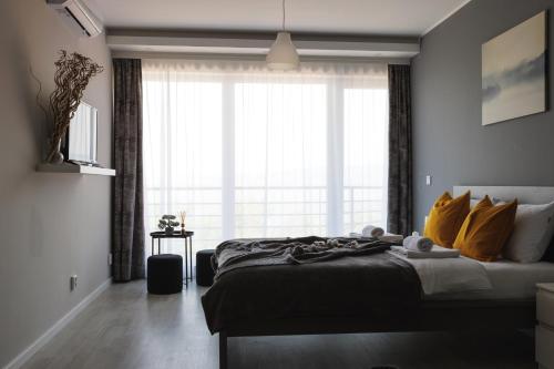 ein Schlafzimmer mit einem Bett und einem großen Fenster in der Unterkunft Horizont Dedine in Golubac