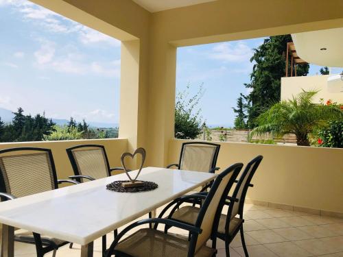 d'une table et de chaises blanches sur un balcon. dans l'établissement Sea View Villa Giorgios Five Bedroom, à Gavalochori