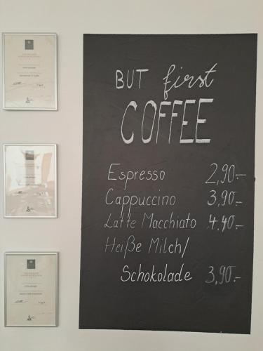 Una pizarra con un cartel del primer café en la pared. en Landhotel Ölmühle, en Mömbris