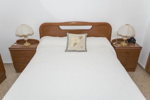 ein Bett mit zwei Nachttischen und zwei Lampen in der Unterkunft Frontalmar, Esc-A, 8º-29 in Cullera