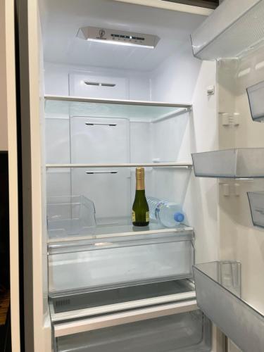 um frigorífico vazio com uma garrafa de vinho em Beautiful Las Rosas em Arona