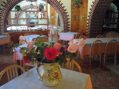 un vaso con fiori su un tavolo in un ristorante di Grotta dei Colombi a Scanno