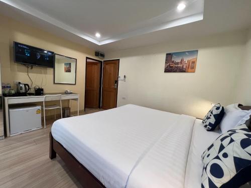 a bedroom with a large white bed and a desk at V Check inn Sukhumvit 22 in Bangkok