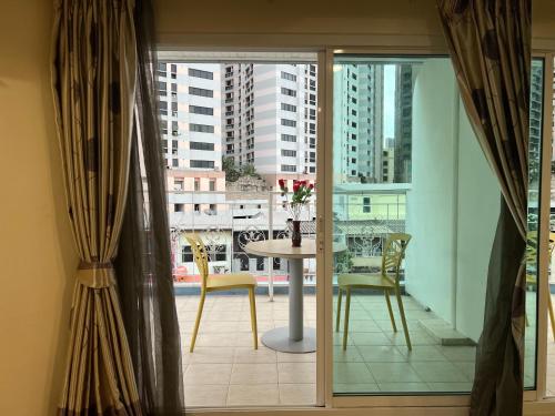 a room with a table and chairs and a window at V Check inn Sukhumvit 22 in Bangkok