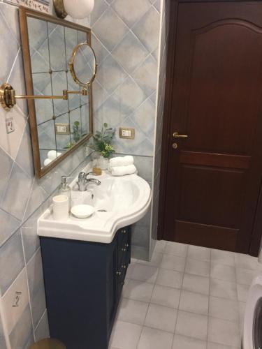 een badkamer met een wastafel en een spiegel bij IL NIDO DI ARETUSA apt by Addler House Ospitality in Siracusa
