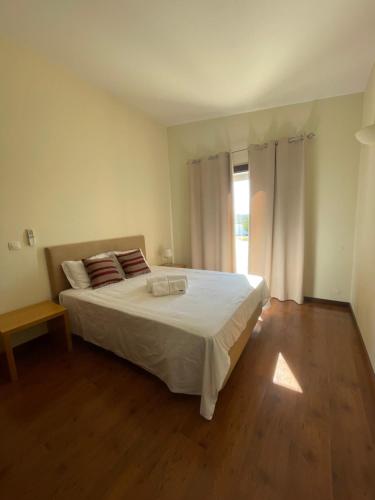 a bedroom with a large white bed and a window at Herdade do Gizo - Casa Reis in Cuba