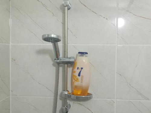 una botella de limpiador sentada en una ducha en רימון יחידות אירוח Vacation units RIMON, en Ashkelon