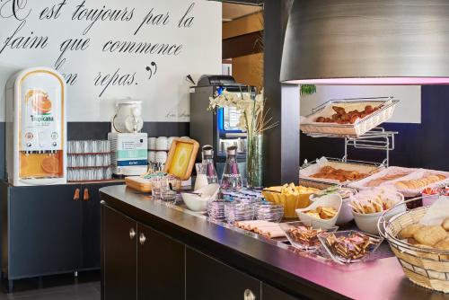 a kitchen with a counter with food on it at Kyriad Tarbes Bastillac in Tarbes