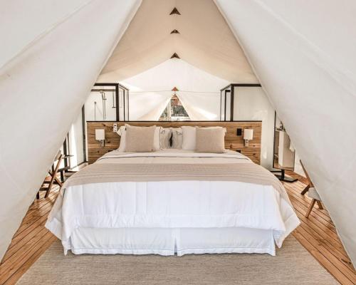 ペトロポリスにあるGlamping Cabanas do Valeのテント内の大型ベッド付きのベッドルーム1室